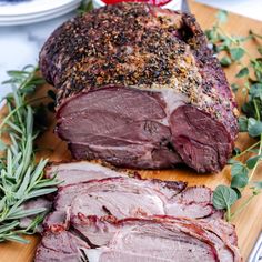 sliced roast beef with herbs and seasoning on a cutting board, ready to be served