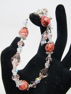 "These ROSE CERAMIC BEADS almost look like STONE! The color is so rich and the variations just beautiful! SO skillfully made! The ceramic beads (4 of them) are 10x14mm, along with clear and blush crystals, soft rose colored glass bicones, and some Czech glass. The bracelet adjusts from 6.5\" to 7.5\" in length and secures with a lobster clasp. I can lengthen/shorten somewhat upon request. The beadcaps, spacers, findings, chain and clasp are pewter and silver plate. I LOVE the colors and the way Pink Crystal Beaded Round Bracelets, Elegant Adjustable Glass Crystal Bracelet, Pink Crystal Bracelets With Round Beads, Pink Crystal Bracelets With Faceted Beads, Adjustable Pink Bracelets, Pink Czech Glass Bracelets With Faceted Beads, Adjustable Pink Glass Bracelets, Adjustable Glass Crystal Bracelet With Faceted Beads, Adjustable Pink Crystal Bracelet With Faceted Beads