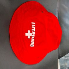 Lifeguard Hat. Has Bright Red Color. Lifeguard Logo In Front. Great Coverage For Sun Protection. New Without Tags Red Beach Cap, Casual Red Cap Sun Hat, Adjustable Red Bucket Hat, Red Cap For Vacation, Casual Red Bucket Hat For Beach, Casual Red Bucket Hat For The Beach, Red Cap-shaped Sun Hat, Red Outdoor Bucket Hat With Short Brim, Red Adjustable Bucket Sun Hat