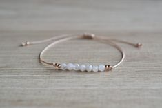 Natural moonstone string bracelet; simple string wish bracelet - Minimalist string bracelet with adjustable sliding closure. - Dainty rose gold plated stainless steel beads. - 4 mm round faceted tiny white moonstone beads. - Beige strong string. - A string bracelet is a symbolic gift to be offered to anyone, as a lucky charm bracelet - Ready to give it as a gift this bracelet comes wrapped in one nice jewelry bag. If you have any questions about this item please feel free to leave a message. If Elegant Jewelry With Adjustable Cord And Round Beads, Handmade Minimalist Moonstone Bracelets, Minimalist Handmade Moonstone Bracelets, Delicate Adjustable Bracelet With Faceted Beads, Adjustable Dainty Moonstone Jewelry, Adjustable Elegant Moonstone Beaded Bracelets, Delicate Beaded Bracelet With Adjustable Chain, Adjustable Rose Gold Jewelry With Sliding Knot, Adjustable Minimalist Rose Gold Jewelry