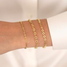 Our 14k Gold 4mm Oval Cable Chain Bracelet exudes understated elegance. This small yet intriguing piece is intended to add a touch of refined beauty to your wrist. The flat oval cable chain has a timeless charm that can go with any outfit. With three chain width options: 3.0mm, 4.0mm, and 4.5mm, you can customize your bracelet to your personal taste. This bracelet is a monument to your great taste and the timeless beauty of solid gold, whether it's a treasured anniversary gift or a mark of appre Delicate Oval Link Gold Bracelet As Gift, Gold Oval Link Bracelet With Delicate Chain For Gift, Dainty Oval Chain Bracelet, Dainty Oval Bracelet For Everyday, Dainty Oval Chain Bracelet Gift, Minimalist Oval Chain Bracelet With Solid Links, Minimalist Tarnish Resistant Oval Bracelets, Elegant Oval Chain Bracelet For Everyday, Elegant Oval Gold Cable Chain Bracelet