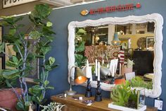 a store front with plants and candles on display