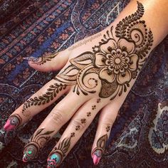 a woman's hand with hennap on it and flowers painted on the palm