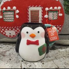 a penguin with a red bow tie is next to a christmas ornament