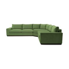 a green sectional couch sitting on top of a white floor