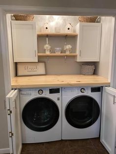 a washer and dryer in a small laundry room with cabinets above the washer