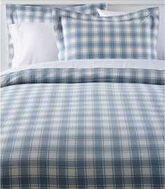 a blue and white plaid comforter set on a bed