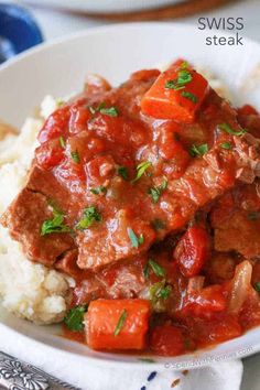 a white bowl filled with meat and vegetables on top of mashed cauliflower