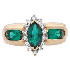 Magnificent ladies cocktail ring. This ring is centered by a beautiful prong set marquise shaped Green Synthetic Emerald. Accentuated with round cut diamonds in a halo setting with oval shaped synthetic emeralds on each side. Mounted in fine 14k yellow gold. Handcrafted masterpiece design. Ring size: 6.5. Total weight: 4.28 grams. Great pre-owned condition. Comes with a presentable gift box. Collectible Green Multi-stone Emerald Ring, Green Multi-stone Emerald Ring Fine Jewelry, 14k Gold Emerald Ring With 17 Jewels - Collectible, Vintage Multi-stone Emerald Ring In 14k Gold, Yellow Gold Emerald Ring, Oval Cabochon Gift, Ladies Ring, Halo Setting, Emerald Diamond, Round Cut Diamond