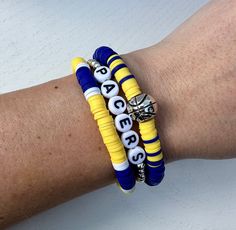 "These handmade stackable bracelets get you ready for game day!  Price includes THREE bracelets (multiple options for stacks). If you want to customize your stack, please message me! Made with yellow, blue and white Heishi beads, seed beads and high quality stretchable string for durability. Ships within the normal 1-3 business days.  Size 6 fits kids, size 6.5 fits small wrists and size 7 fits most. If a larger size is needed, please let us know (measure wrist tightly with no slack, adding .5\" to find your perfect fit). Not seeing the colors or style you're looking for? Message for custom orders at no additional charge. CARING TIPS: These bracelets are made with quality stretch cord, but are still delicate. Please be careful when taking them on and off. Rolling is best. For longevity, do Team Bracelets, Bracelets Beaded, Sports Bracelet, Bracelets Set, Indiana Pacers, Stackable Bracelets, Heishi Beads, Cute Bracelets, Exercise For Kids