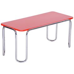 a red table with two metal legs and a plastic top on the bottom, against a white background