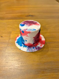 a red, white and blue cup sitting on top of a wooden table