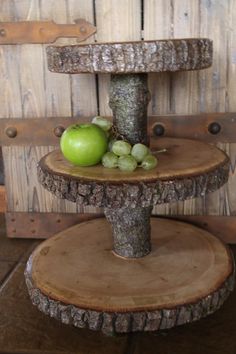 two tiered wooden stand with apples and grapes on it