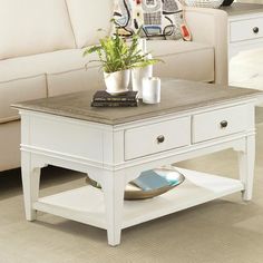 a living room with a couch, coffee table and two end tables on the floor