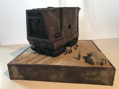 a model train car sitting on top of a wooden box next to rocks and dirt