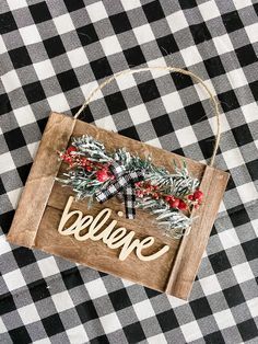 a black and white checkered table cloth with a wooden sign that says believe