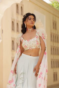 Featuring Georgette Fish cut skirt with ruffle details. Paired with embroidered Chiffon printed blouse, patch of net on both the sides. Cones along with shoulder embroidered cape with floral chiffon flare. Summer Dresses With Floral Embroidery And Cape Sleeves, Floral Embroidered Choli With Cape Sleeves For Parties, Party Choli With Cape Sleeves And Floral Embroidery, Party Choli With Floral Embroidery And Cape Sleeves, Georgette Dress With Ruffles And Cape Sleeves, Embroidered Sets With Cape Sleeves For Summer, Embroidered Summer Sets With Cape Sleeves, Embroidered Lehenga With Cape Sleeves In Organza, Spring Designer Dress With Cape Sleeves