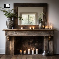 candles are lit in front of an old fireplace with a mirror above it and vases on the mantle