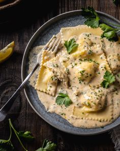 a plate of ravioli with cheese sauce and parsley