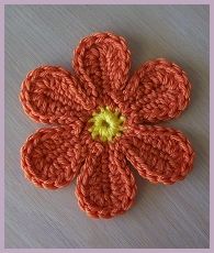 an orange crocheted flower with green center