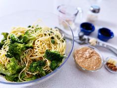 broccoli and noodles are in a bowl on the table next to other ingredients