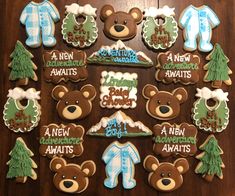 baby shower cookies decorated with teddy bears and snowsuits are arranged on a table