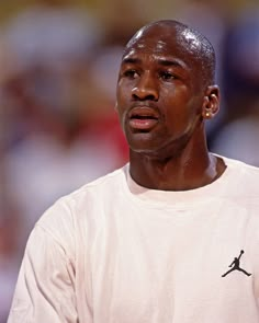 a close up of a person wearing a white shirt and holding a tennis racket