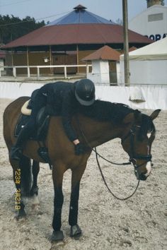 a person riding on the back of a brown horse