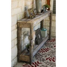 a wooden shelf sitting on the side of a brick wall next to a potted plant