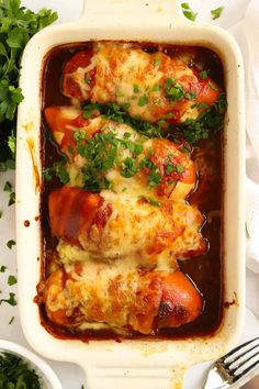 two stuffed lobsters covered in sauce and garnished with parsley