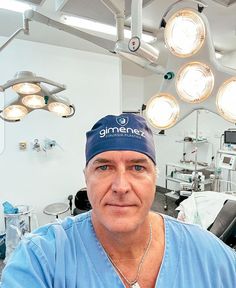 a man in blue scrubs and surgical lights