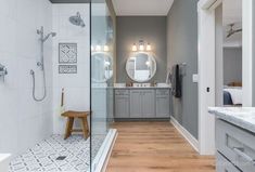 a bathroom with a walk in shower next to a bathtub and two sink basins