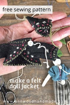 a hand holding a doll and sewing needles with text overlay that reads free sewing pattern make a felt doll jacket