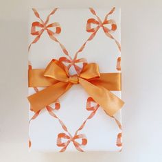 an orange bow on top of a white gift box