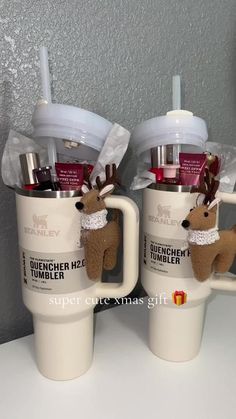 two coffee mugs with reindeer decorations on them