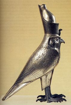 a silver bird statue sitting on top of a table