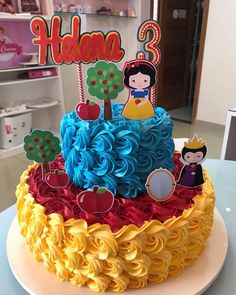 a birthday cake decorated with colorful icing and princess figures on it's top