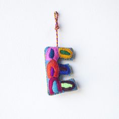 an ornament made to look like the letter e is hanging on a string