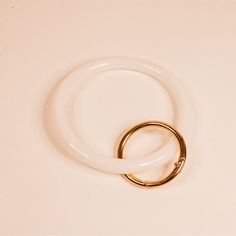 a pair of gold rings sitting on top of a white surface