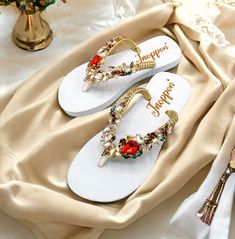 Description The beautiful rhinestone and customizable Flip Flops for the beach brides, bridesmaids, vacation, honeymoon or any occasion you desire to look gorgeous. Perfect in any outfit! Being unique and stunning on design, these flip flops must be your must-have item! The sandal is anti-slip, comfortable and durable as it is made from high quality rubber from the South of Thailand, where is famous for the best rubber tree. Moreover, the crystals are decorated on the sandal with effective adhesive glue and knitting threads by hand stitching. Don't worry when you walk on the beach or use it in the rainy season. For anyone who loves a real handmade product, don't miss it out! Product Description: - Thailand High-Quality Rubber Sole - Luxury Crystals/Rhinestones  - High-quality PU gold threa Summer Wedding Shoes With Rhinestones And Round Toe, Summer Wedding Shoes With Rhinestones, Elegant Party Flip Flops With Open Toe, Elegant Open Toe Party Flip Flops, Elegant Party Flip Flops, Embellished Sandals For Beach Party, Embellished Sandals For Beach Season Parties, Summer Party Flip Flops With Rhinestones, Gold Sandals For Summer Beach Wedding