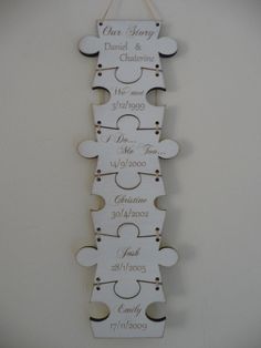 a wooden puzzle piece with the names and date on it, hanging from a wall