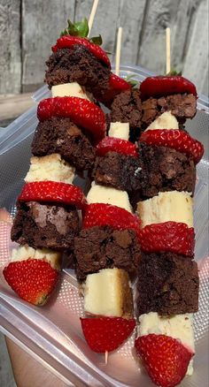 strawberries and chocolate brownies on skewers in a plastic container