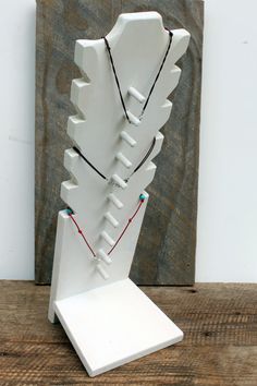 a white sculpture with multiple necklaces on it