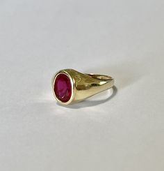 Amazing vintage 14k yellow gold created ruby ring, circa 1960s! The created red ruby weighs an estimated 1.21 carats, is oval cut, and is a stunning deep red. The setting contains a classic design with a high polish finish. Classic statement piece of fine retro jewelry showcasing a stunning created ruby, circa 1960s! ERA - Circa 1960s, Retro METAL / MATERIAL - 14k yellow gold, 1 created ruby (estimated 1.21 carats) [Synthetic ruby contains essentially the same chemical composition & properti Yellow Gold Ruby Signet Ring With Polished Finish, Heirloom Red Gold Signet Ring, Gold Ruby Signet Ring With Polished Finish, Vintage Ruby Rings With Polished Finish, Vintage 14k Gold Ruby Ring With Polished Finish, Classic 14k Gold Red Signet Ring, Classic Red 14k Gold Signet Ring, Classic Red Signet Ring Stamped 14k, Heirloom Style Ruby Ring