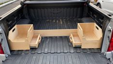 the back end of a truck with two wooden seats