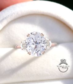 a close up of a person's hand holding an engagement ring