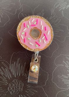 "This cute pink donut with sprinkles badge reel makes the perfect accessory for anyone that wears a badge.  Made with a pink vinyl, clay sprinkles and a gold sparkly glitter.   Each 2\" acrylic blank is handcrafted with high quality polyester glitter and epoxy resin.  The badge  is glued to your choice of alligator clip or belt clip Specialist ID badge reel with a retractable 34\" nylon cord.  Please handle with care.  Acrylic blanks and resin can break if dropped or knocked against a hard surfa Circle Badge Reel Ideas, Pink Novelty Craft Supplies For Birthday, Novelty Pink Craft Supplies For Birthday, Novelty Pink Badge Holder For Birthday, Cute Pink Badge Reel For Birthday, Summer Badge Reel, Badge Reels Diy Ideas, Badge Reel Ideas, Nurse Crafts