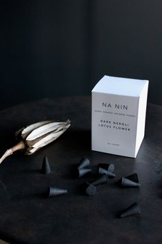 a white box sitting on top of a table next to some black cones and other items