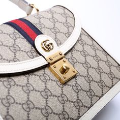 This Gucci Ophidia Small Top Handle Bag . The exterior is in the classic Gucci GG Supreme coated canvas. Condition: Very Good Serial Number: 651055 520981 Color: Tan and White Exterior: The exterior coated canvas is free from any rips or cracks. The corners show minor wear. Handle: The leather handles are free from any major signs of wear. Strap: The shoulder strapis free from wear. The strap has embossed initials. Hardware: The clasp closure has minor scratches. Interior: The interior features one zipper pocket and one open pocket. The interior is clean and free of any major signs of wear. Dimensions: L: 9.75" / H: 6.75" / D: 3.5" Handle Drop: 4" Strap Drop: 19" (Adjustable / Removable) Not Included: Original Dust BagFree delivery over $100 | Delivery 5-8 or 10-15 working days Please note Signature Coated Canvas Top Handle Shoulder Bag, High-end Bag With Adjustable Strap And Coated Canvas, High-end Bag With Adjustable Strap In Coated Canvas, High-end Coated Canvas Satchel With Detachable Strap, High-end Coated Canvas Crossbody Satchel, Designer Crossbody Bag In Signature Coated Canvas, Designer Signature Coated Canvas Crossbody Bag, High-end Beige Coated Canvas Shoulder Bag, High-end Bags With Detachable Strap In Coated Canvas