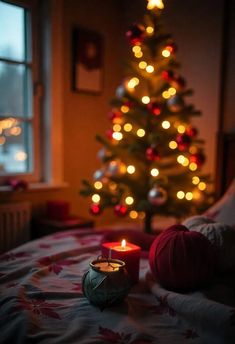 a lit candle sitting on top of a bed next to a christmas tree